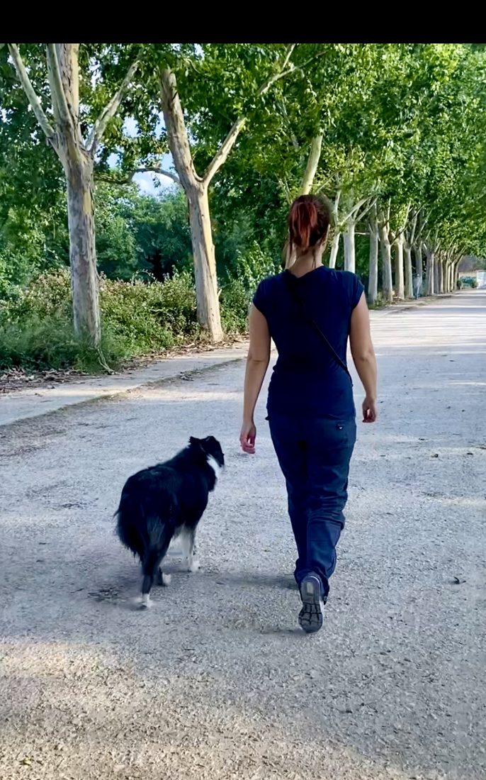 Noemí paseando con su perra por un parque